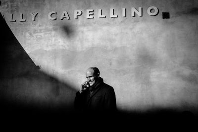 Portrait of young man standing against wall