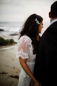 Rear view of couple standing at beach