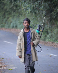 Portrait of young man with dog on road