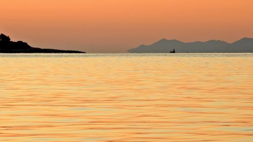 Scenic view of sea against orange sky