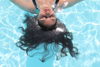 High angle view of young woman swimming in pool