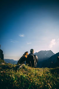 Rear view of men with umbrella on land against sky