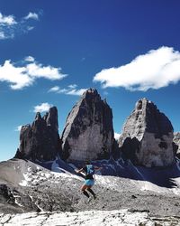 Rear view of man on snowcapped mountains against sky