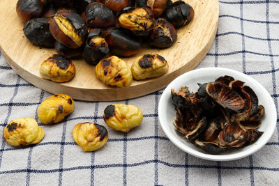 Fresh roasted chestnuts on a table with peels. close-up