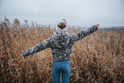 Rear view of woman standing on field