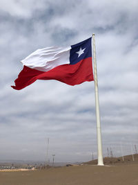 Low angle view of flag flags against sky