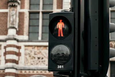 Road sign on street against building in city