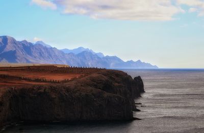 Scenic view of sea and mountains against sky