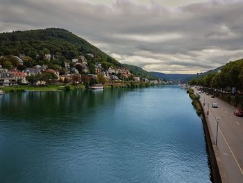 Scenic view of river by mountains against sky