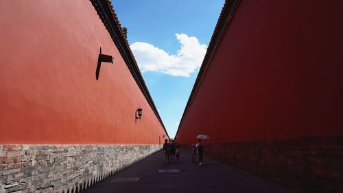 People walking on road amidst buildings against sky