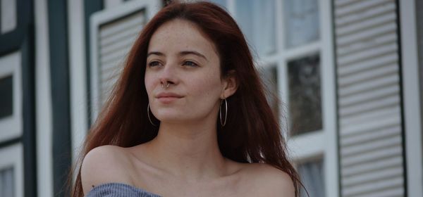 Portrait of beautiful woman looking through window