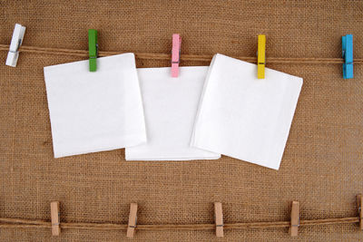Close-up of clothespins hanging against white wall