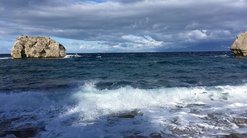 Rocks in sea against sky