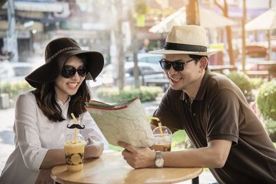 Couple reading map while having drinks at restaurant