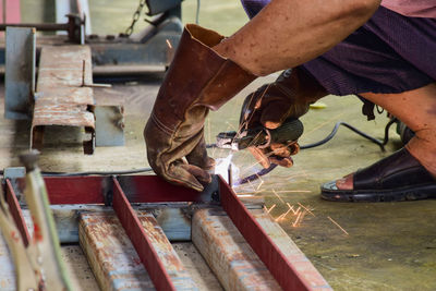 Low section of man working on metal