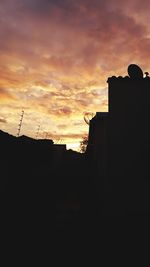 Low angle view of silhouette buildings against dramatic sky