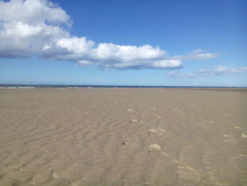 Scenic view of beach against blue sky