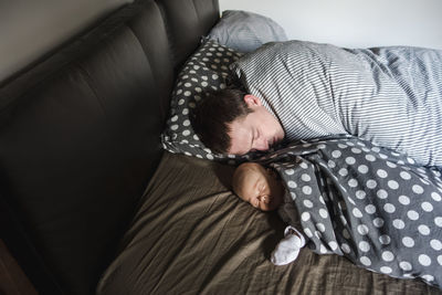 Low section of woman sitting on bed at home