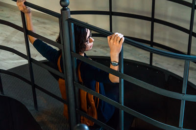 High angle view of man sitting on railing