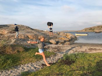 Full length of girl at seashore playing on field