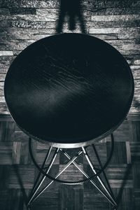 Close-up of metallic structure on table against wall