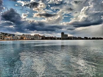 Scenic view of sea by buildings against sky