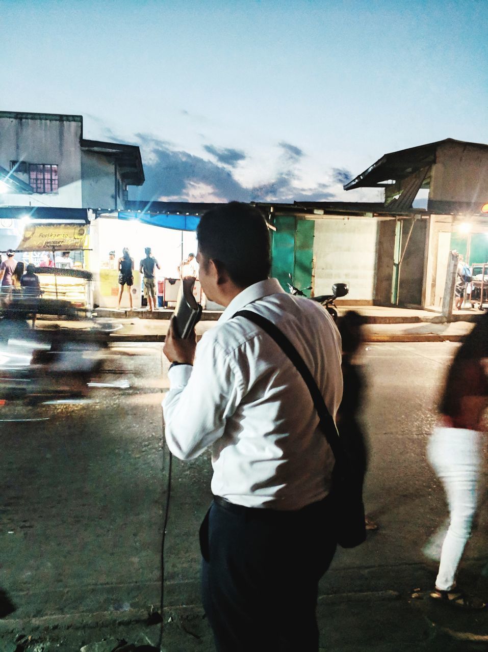 FULL LENGTH REAR VIEW OF MAN STANDING ON STREET