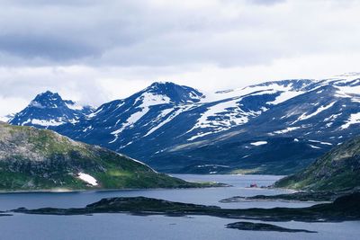 Scenic view of snowcapped mountains against cloudy sky