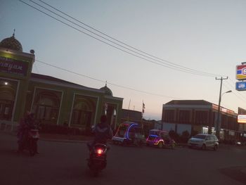 Cars on road against sky in city