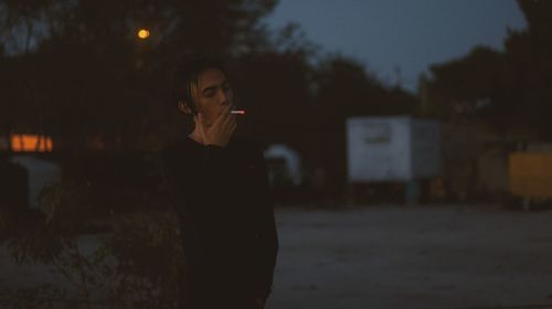 Side view of woman standing against wall