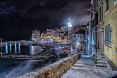 Illuminated buildings by street in city at night