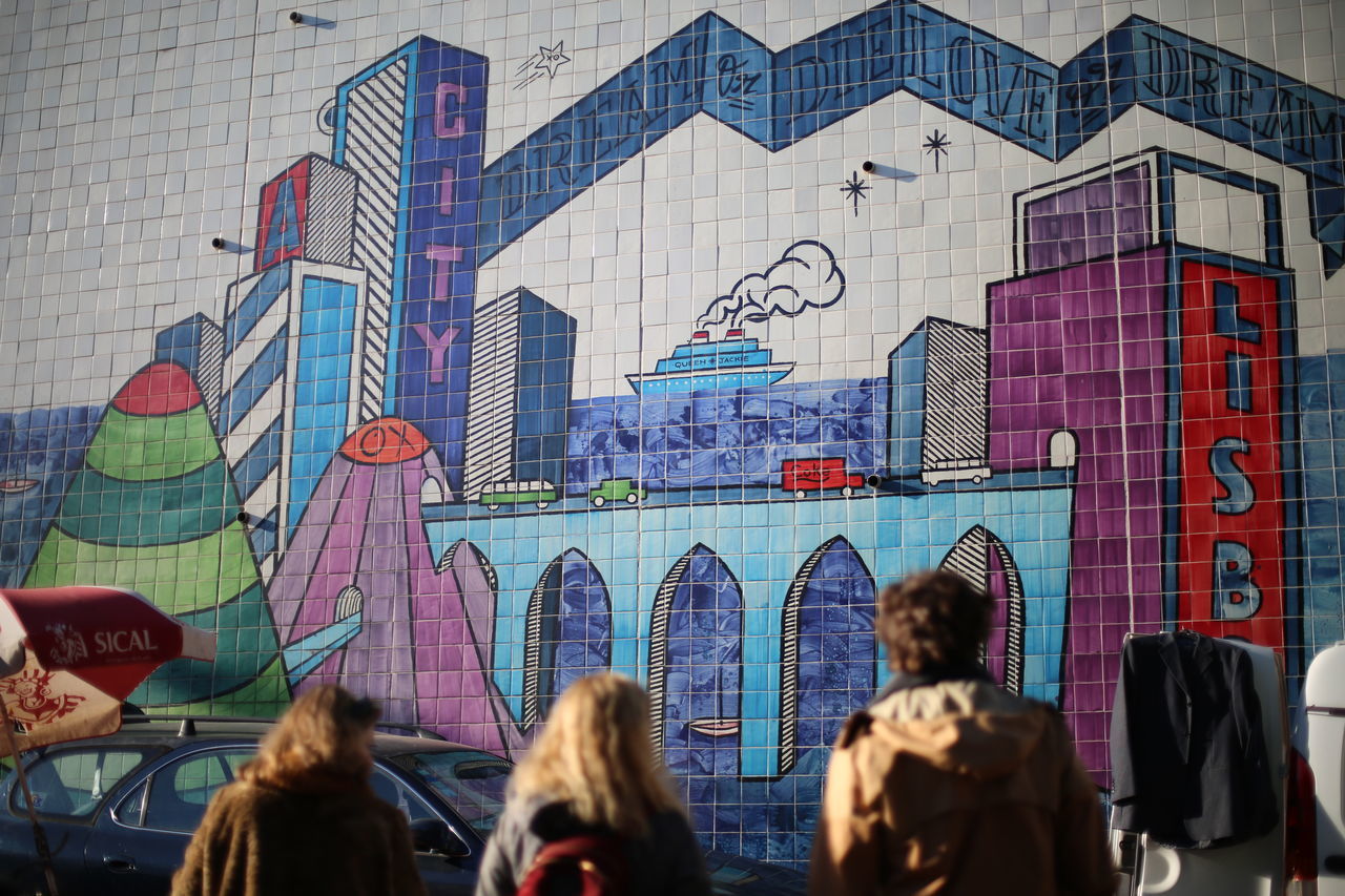 GROUP OF PEOPLE ON STREET AGAINST BUILDINGS