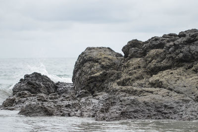 Rock formation on sea against sky