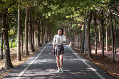 Ethnic asian female walking in tanya shen green bikeway looking away