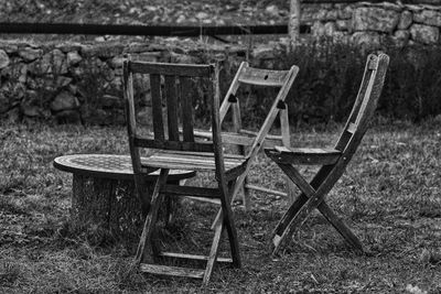 Empty chairs and table on field