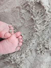 Close-up of hand on sand
