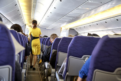 Rear view of airhostess in airplane