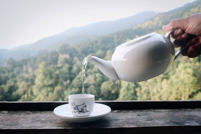 Coffee cup on table against mountains