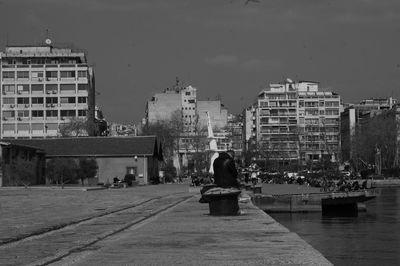 Woman in city against sky