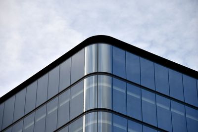 Low angle view of glass building against sky