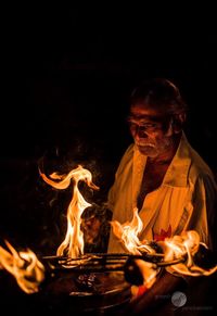 Close-up of man burning at night