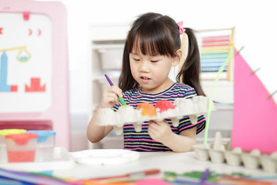 Cute girl playing with toy at home