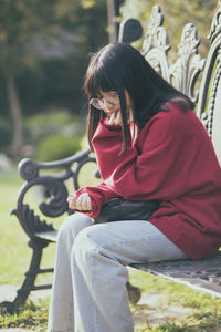 Teenager girl sitting on bench at park