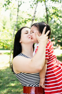 Mother embracing daughter while standing outdoors