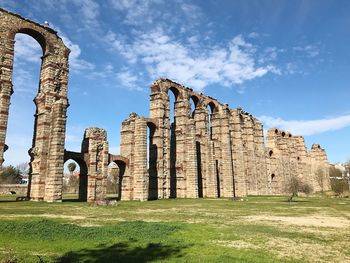 Low angle view of old ruin on field against sky