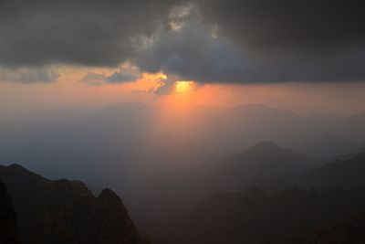 Sun shining on mountains through clouds