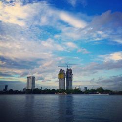 Building by river against cloudy sky