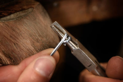 Extreme close-up of manual worker holding work tool while working in workshop