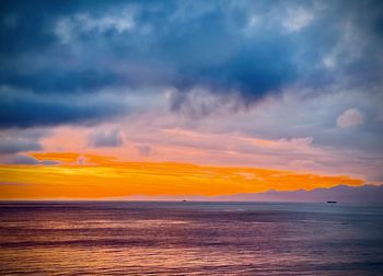 Scenic view of sea against dramatic sky during sunset