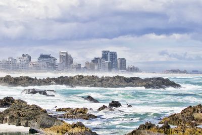 Panoramic view of sea and cityscape against sky